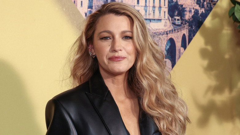 Blake Lively posing in a leather blazer.