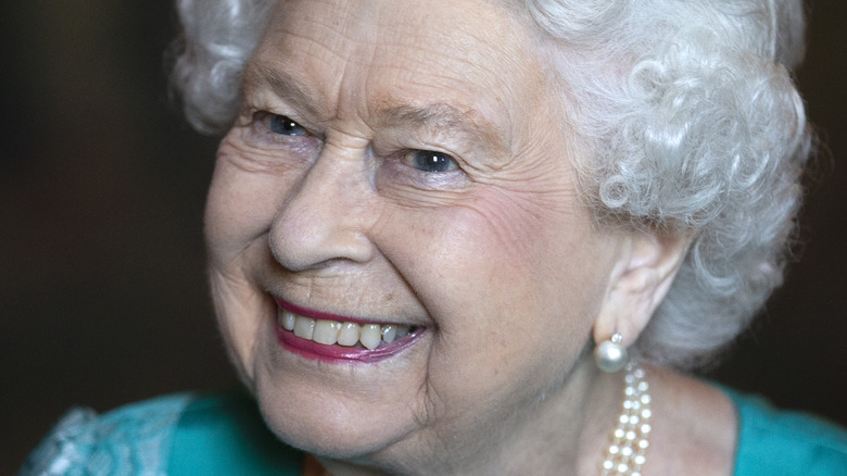 Queen Elizabeth smiling in blue outfit
