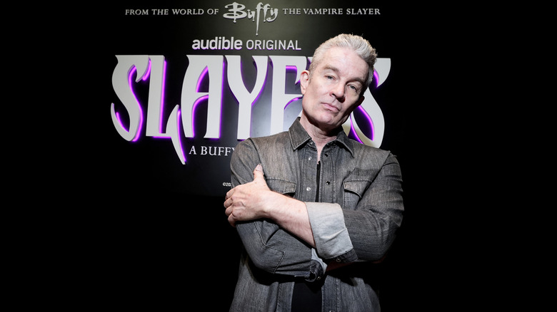 James Marsters posing in front of a Slayers poster