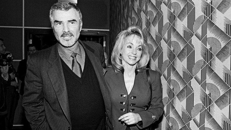 Burt Reynolds and Pam Seals smile with their arms around each other's backs in 1998.