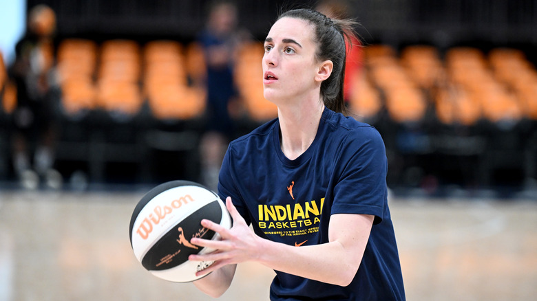 Caitlin Clark basketball court holding basketball