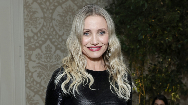Cameron Diaz posing against patterned wallpaper