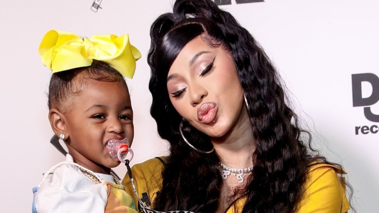 Cardi B holding Kulture on the red carpet at an event