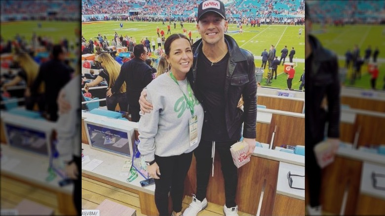 Laura and Carl Lentz smiling in football stadium