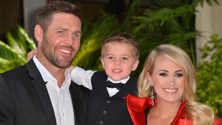 Mike Fisher and Carrie Underwood posing with their son, Isaiah