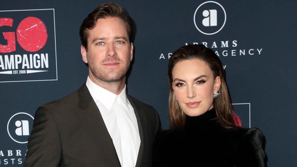 Armie Hammer and Elizabeth Chambers, posing with serious expressions on the red carpet