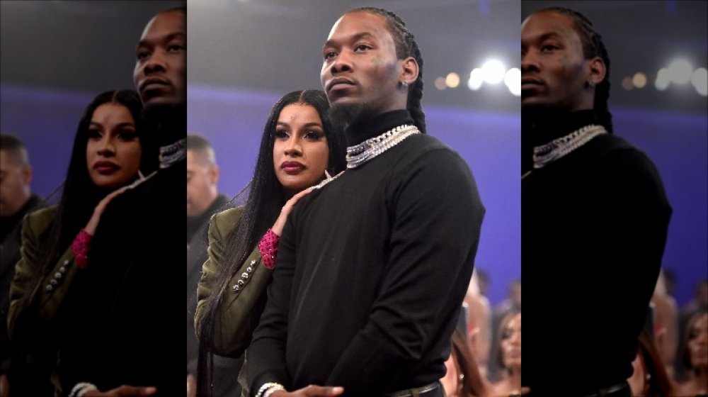 Cardi B with her hands on Offset's shoulder