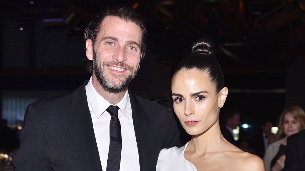 Jordana Brewster with a serious expression and Andrew Form smiling, posing arm-in-arm 