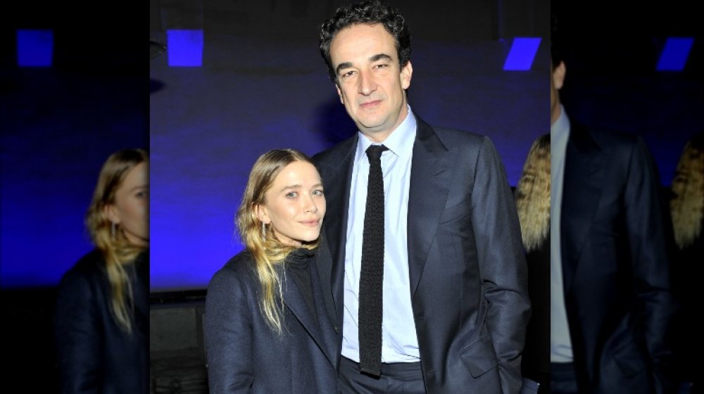 Mary-Kate Olsen and Pierre Olivier Sarkozy, posing arm-in-arm with serious expressions