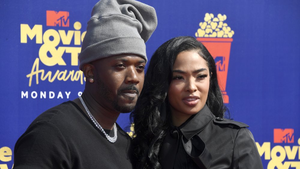 Ray J and Princess Love, wearing all black and posing arm-in-arm on the red carpet