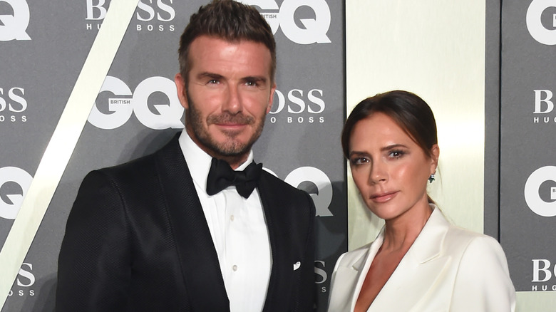 David Beckham in formal attire next to Victoria Beckham