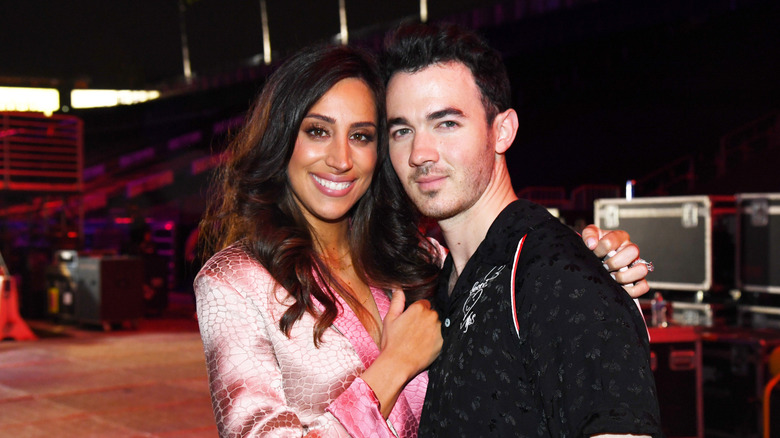 Danielle Deleasa in a pink blazer, hugging Kevin Jonas