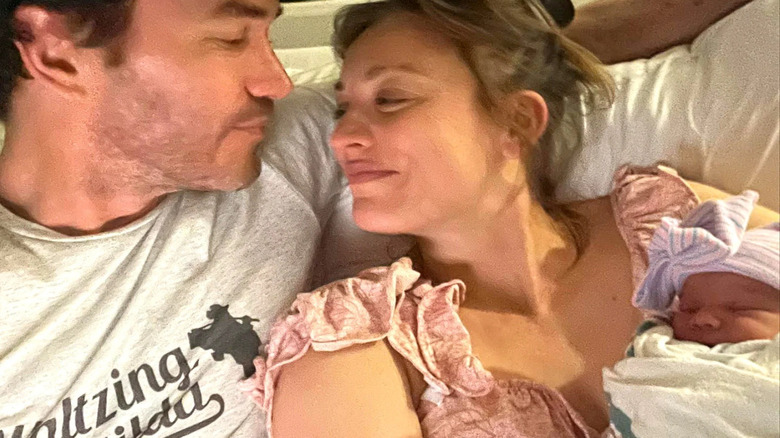 Tom Pelphrey and Kaley Cuoco holding newborn