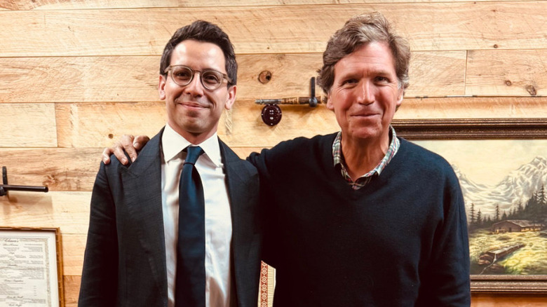 Tucker Carlson poses for a photo with James Fishback