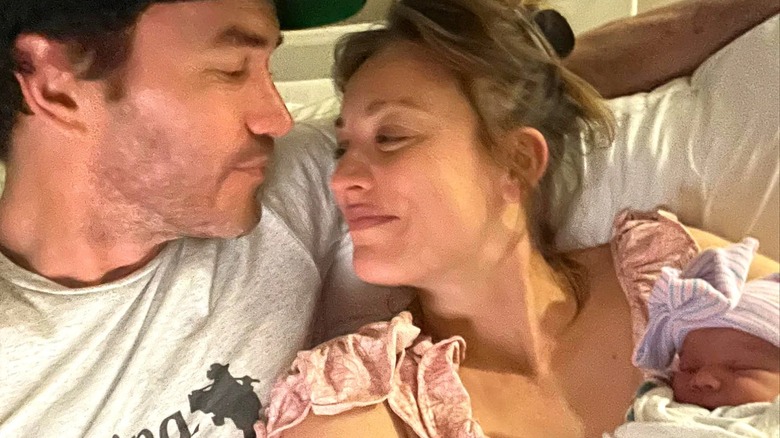 Tom Pelphrey and Kaley Cuoco holding newborn