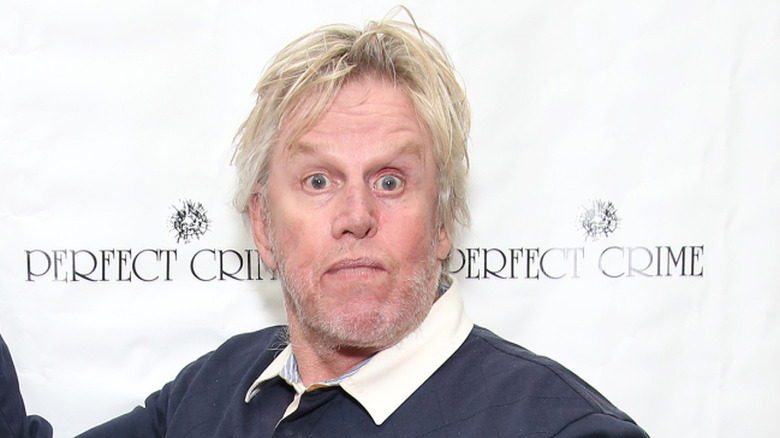Gary Busey posing in front of a white background