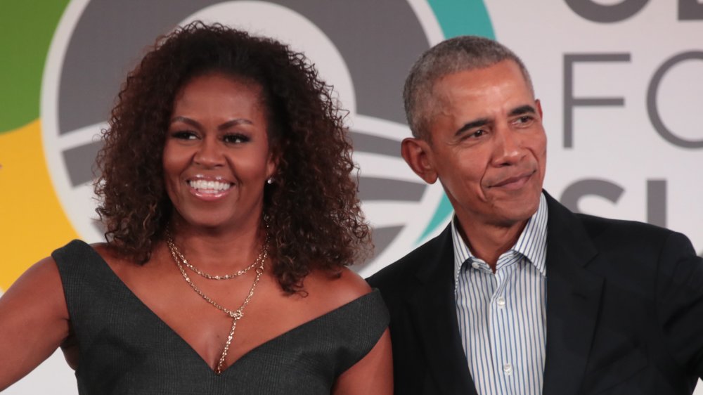 Michelle Obama and Barack Obama both waving at crowd