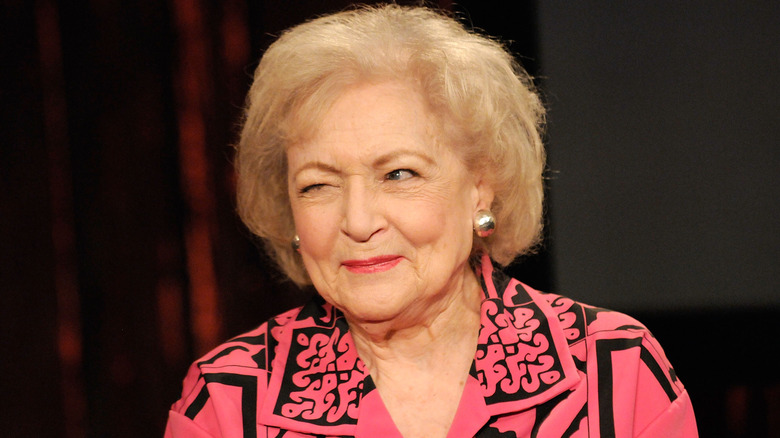 Betty White pink shirt winking smiling