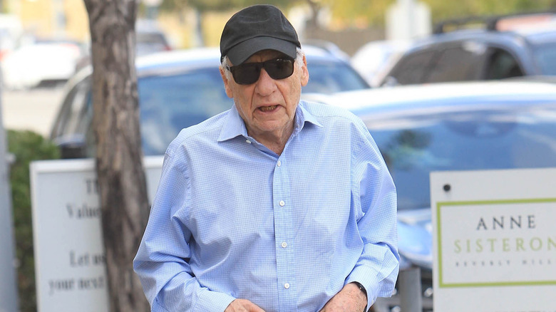 Mel Brooks black baseball hat and sunglasses outside
