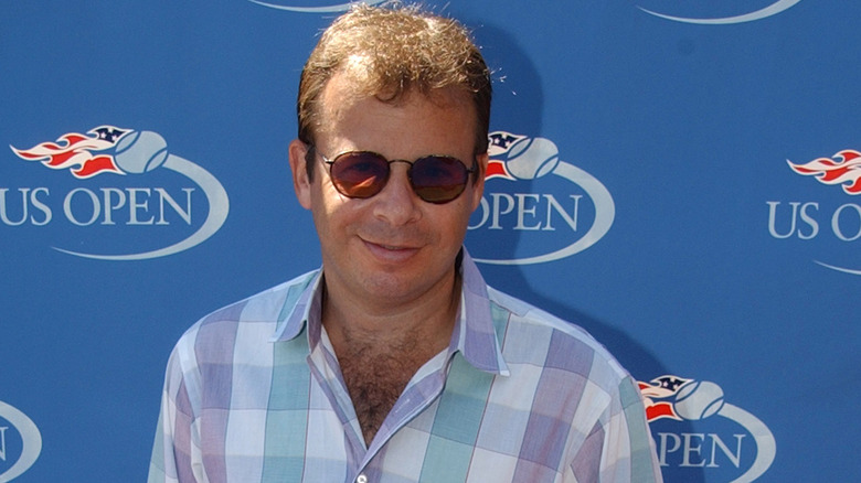Rick Moranis checkered shirt sunglasses smiling at US Open