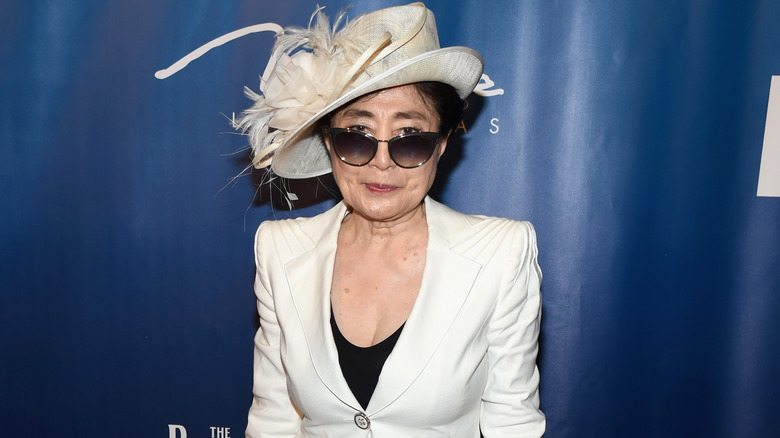 Yoko Ono white suit hat sunglasses at event