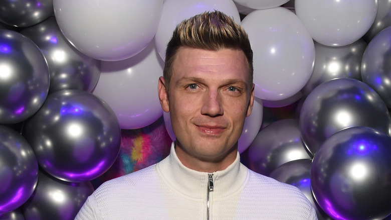 Nick Carter posing in front of balloons