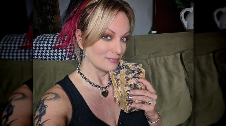 Stormy Daniels holding oracle cards