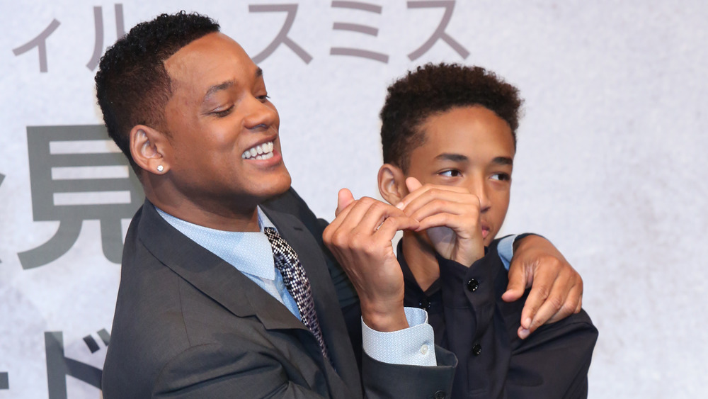 Will Smith next to Jaden Smith form a heart with their hands together