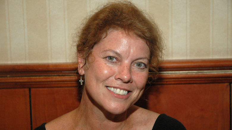 Erin Moran wearing a black top and gold cross earrings