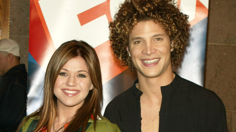 Kelly Clarkson and Justin Guarini smiling at an event