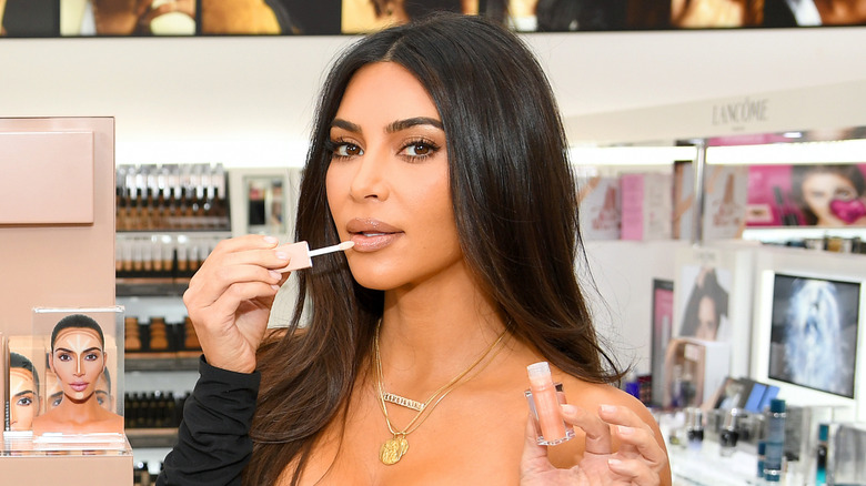 Kim Kardashian applying lip gloss
