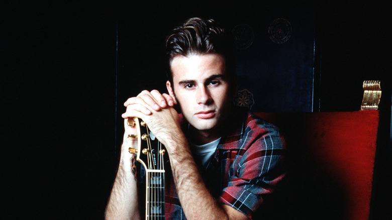 Jamie Walters posing next to his guitar