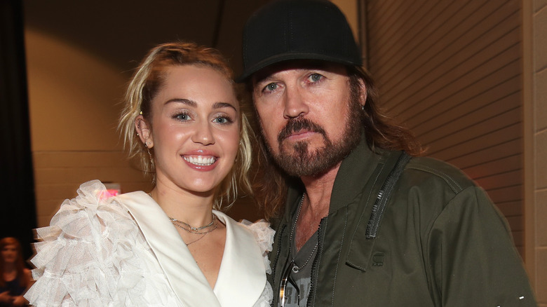 Miley Cyrus posing with Billy Ray Cyrus