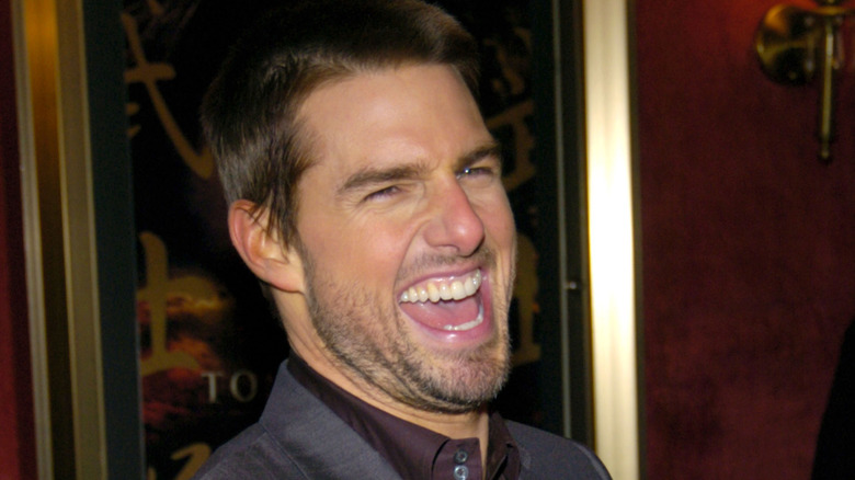 Tom Cruise laughing in grey suit