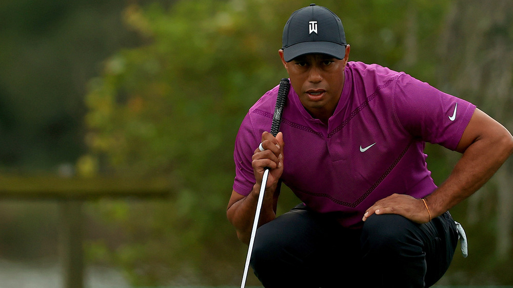 Tiger Woods squats on putting green