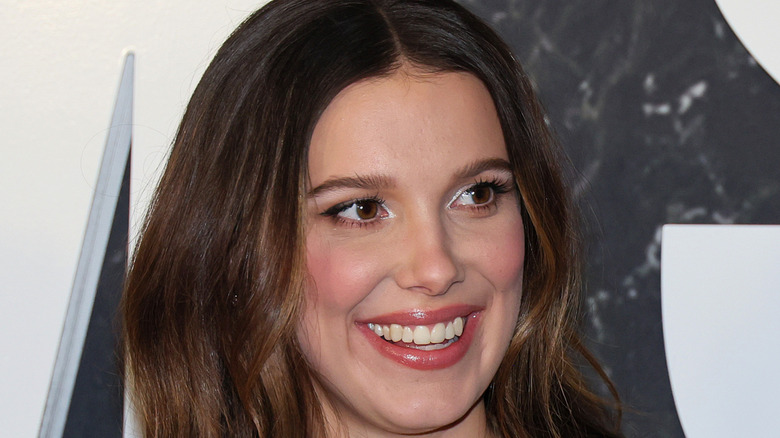 Milie Bobby Brown smiling on an event's red carpet