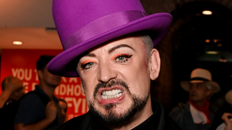 Boy George posing in hat