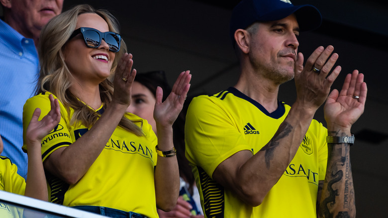 Reese Witherspoon and husband clapping