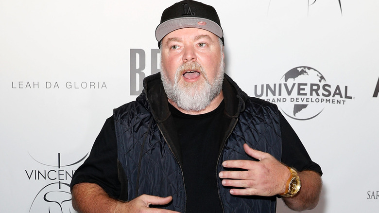 Kyle Sandilands on red carpet wearing a navy-blue hoodie vest
