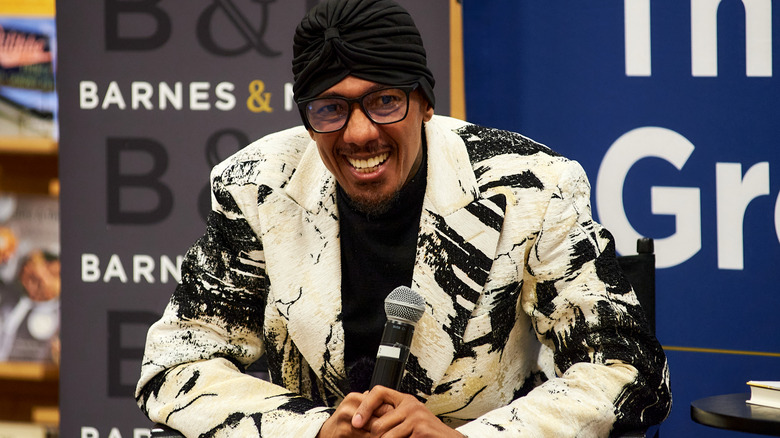 Nick Cannon on stage wearing patterned coat