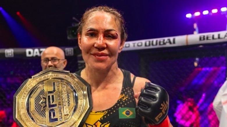 Cris 'Cyborg' Gestino posing with championship belts