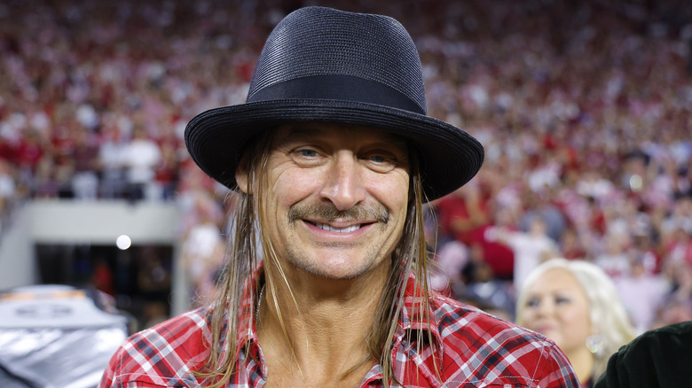 Kid Rock in a black hat and plaid shirt