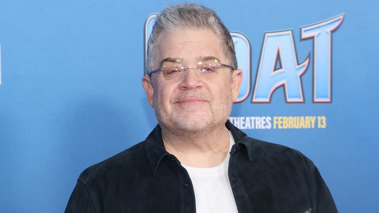 Patton Oswalt photographed in front of a blue background