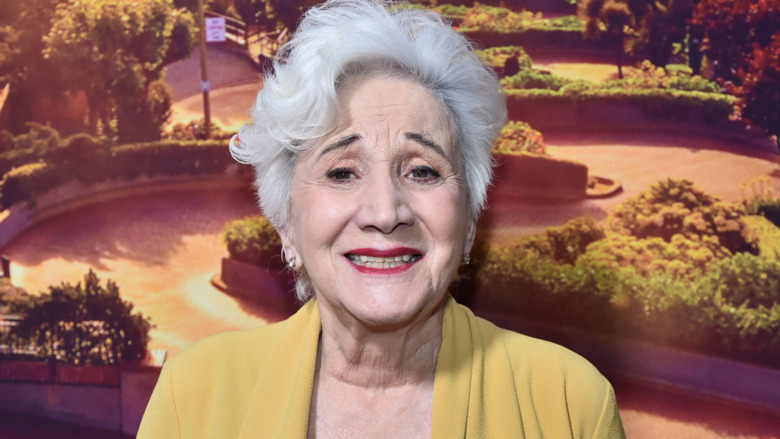 Olmypia Dukakis smiles and wears a black shirt under a yellow cardigan at the premiere of "Tales of the City" in New York City on June 3, 2019.