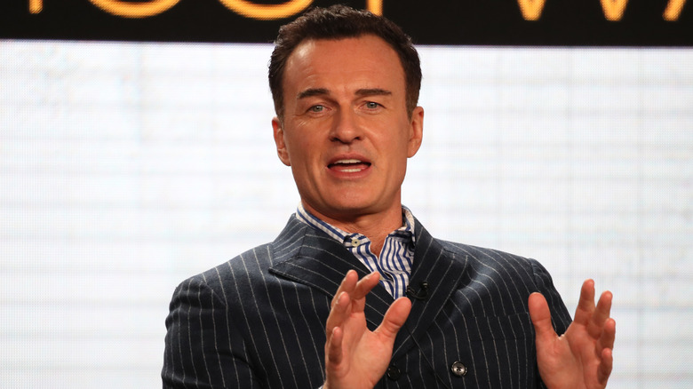 Julian McMahon speaking on stage.
