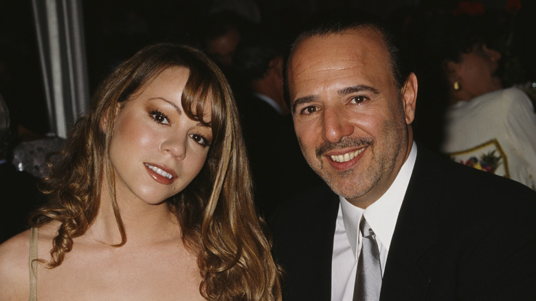 Mariah Carey and Tommy Mottola sitting and smiling at a table