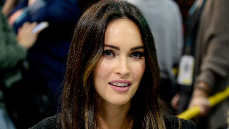 Megan Fox at a table for a fan event