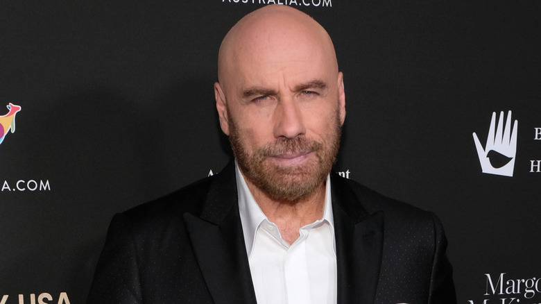 Bald John Travolta looking at camera