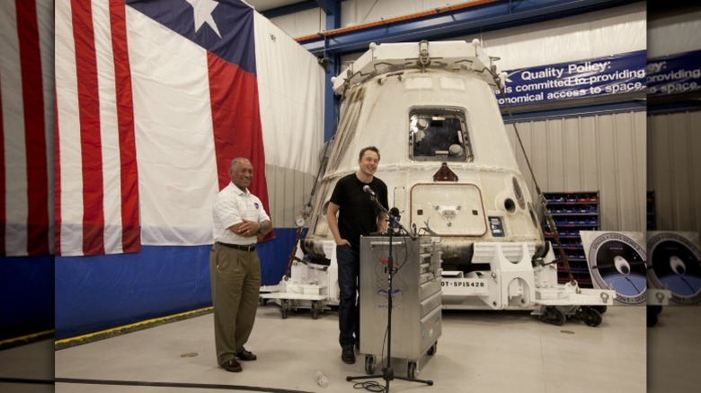 Elon Musk speaks in front of a spacecraft featuring the Texas flag in the background