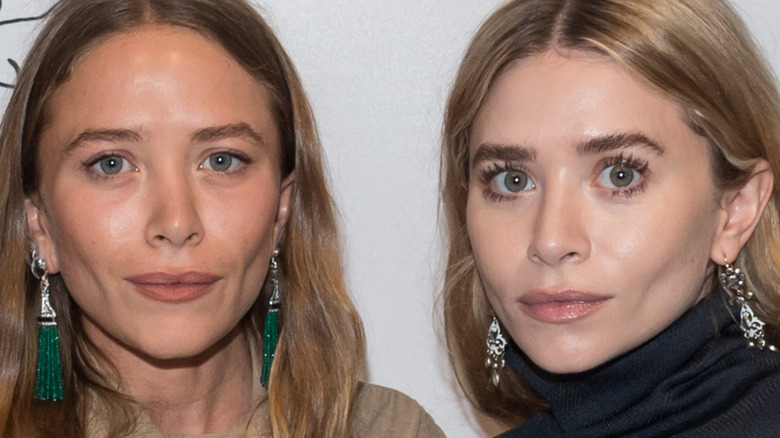 Mary Kate and Ashley Olsen posing